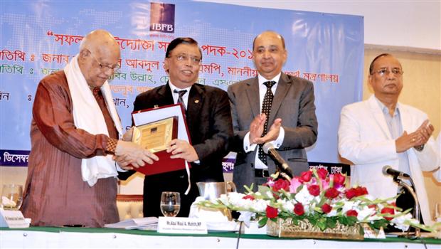 Mr. Md. Omar Shafayat Kausar, Vice President of IBFB is handing over a crest to the Hon’ble Finance Minister Mr. AMA Muhith, MP. Mr. Hafizur Rahman Khan, President of IBFB (2nd from right) and Mr. KM Habib Ullah, Chairperson of SME Foundation (extreme right) are also seen.